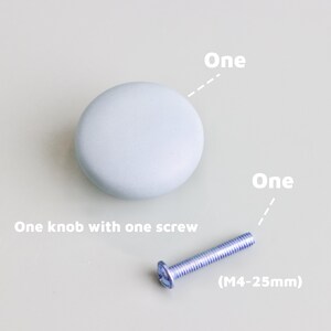 Op de afbeelding: Een lichtblauwe, ronde kastknop met bijpassende schroef. De tekst op de afbeelding luidt "One knob with one screw" en "(M4-25mm)".