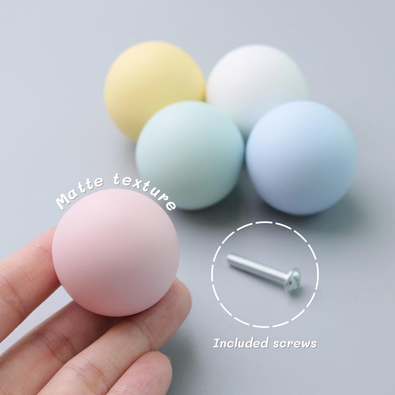 May include: A collection of pastel-colored, matte-finish cabinet knobs. The knobs are in shades of pink, yellow, blue, and white. The image also shows a screw, with the text "Included screws".