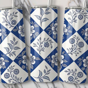 May include: Three stainless steel tumblers with a floral design. The tumblers feature a blue and white checkered pattern with detailed illustrations of flowers and leaves. Each tumbler has a silver lid and a straw.
