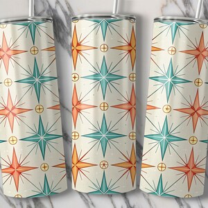 May include: Three stainless steel tumblers with a repeating pattern of orange, teal, and yellow starbursts on an off-white background. Each tumbler has a silver lid and a clear straw. The design is reminiscent of mid-century modern art.