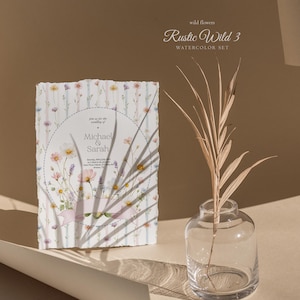 May include: A watercolor wedding invitation with floral illustrations. The invitation features the names "Michael & Sarah" and event details. The design includes a striped background and a decorative ribbon. A clear glass vase with a dried plant is in the background.