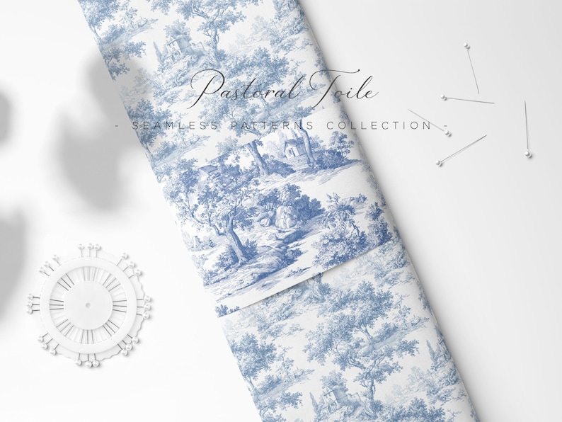 May include: Rolled fabric with a blue and white pastoral toile pattern. The fabric features a detailed landscape design with trees, buildings, and figures. The words "Pastoral Toile" and "Seamless Patterns Collection" are visible. Pins and a pinwheel are also present.