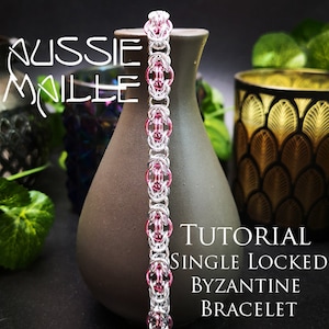 May include: A silver and pink single locked Byzantine chainmail bracelet. The bracelet is on a brown vase with the text "TUTORIAL SINGLE LOCKED BYZANTINE BRACELET".