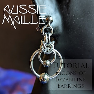 Puede incluir: Pendientes bizantinos plateados con un diseño circular y esferas colgantes. Los pendientes se muestran en una cabeza de maniquí negra. El texto en la imagen dice "AUSSIE MAILLE" y "Tutorial Moons of Byzantine Earrings."