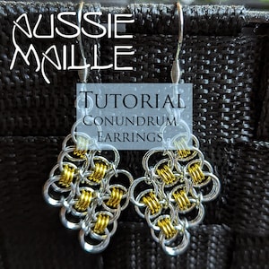 May include: A pair of silver and gold chainmail earrings, called "Conundrum Earrings", are shown against a black background. The earrings are made of small, interlocking metal rings. The earrings are a tutorial project from Aussie Maille.