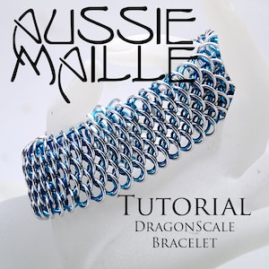Könnte beinhalten: Eine Anleitung zum Herstellen eines blauen und silbernen Drachenschuppen-Armbands. Das Armband besteht aus kleinen Metallringen, die zu einem Muster gewebt sind, das Drachenschuppen ähnelt.