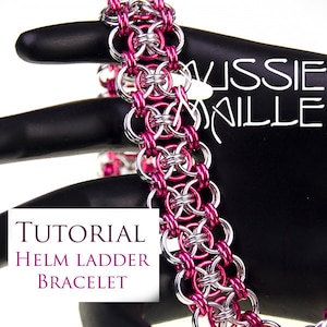 May include: A pink and silver chainmail bracelet, known as a Helm Ladder bracelet, is shown on a black mannequin hand. The bracelet is made of small metal rings that are interlocked in a pattern. The image includes the text "TUTORIAL HELM LADDER BRACELET".