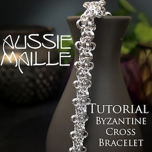 May include: A silver chainmail bracelet with a Byzantine cross pattern. The bracelet is on a gray vase with the text "Aussie Maille" and "Tutorial Byzantine Cross Bracelet".