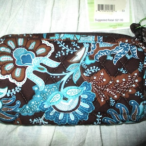 May include: A brown quilted fabric pouch with a zipper closure. The pouch features a floral pattern in shades of blue, brown, and white. The text "Suggested Retail £21.00" is printed on a tag attached to the pouch.