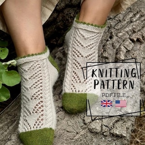 May include: A pair of off-white ankle socks featuring a delicate lace knit pattern, accented with solid green toes, heels, and a scalloped green trim at the cuffs. The image includes the text KNITTING PATTERN PDF FILE with British and American flags.