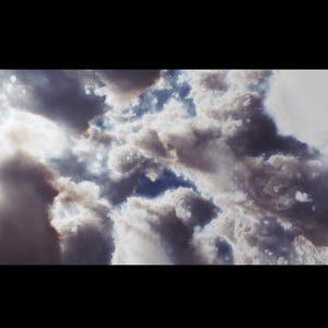 May include: A panoramic view of a cloudy sky. The image shows a mix of white, grey, and brown clouds with patches of blue sky visible. The clouds have a soft, textured appearance, creating a sense of depth and atmosphere.