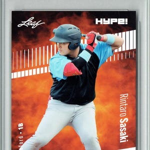 May include: A baseball trading card encased in a protective holder. The card features a player in a baseball uniform, with the text "Rookie Card" at the top. The card also includes the text "Leaf" and "HYPE!"