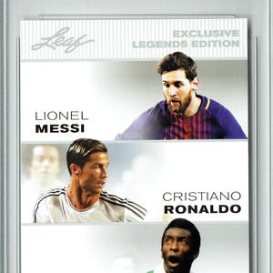 May include: A white card with a red, white, and blue banner at the top that says "G.O.A.T."  The card features three soccer players: Lionel Messi, Cristiano Ronaldo, and Pelé. The card is from the Leaf Exclusive Legends Edition.