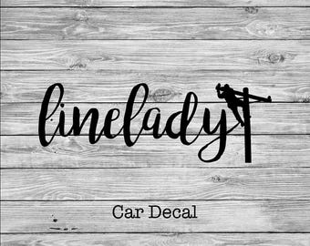 Könnte beinhalten: Schwarz-weißer Autoaufkleber mit dem Text "linelady" und einer Silhouette einer Person, die an einer Stromleitung arbeitet.