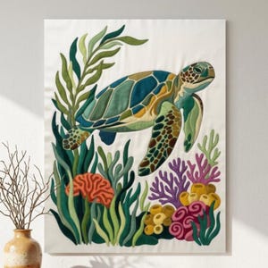 May include: A fabric wall hanging featuring a sea turtle swimming among green seaweed, orange brain coral, purple branching coral, and clusters of yellow and pink sponges on a white background. The design uses layered fabric textures.
