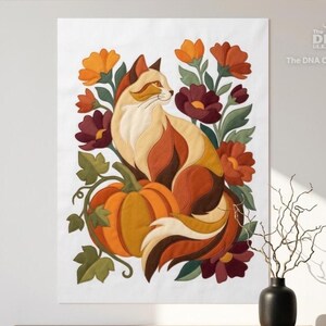 May include: A fabric wall hanging featuring a stylized cat with cream, orange, and brown fur sitting beside a large orange pumpkin. The cat is surrounded by autumn-colored flowers in shades of yellow, orange, and deep red with green leaves.