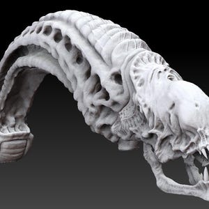 Puede incluir: Un modelo blanco, detallado, impreso en 3D de una criatura extraterrestre con una boca grande abierta y dientes afilados. La cabeza de la criatura está arqueada hacia atrás y su cuerpo está enroscado en forma de C.