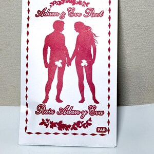 Può includere: Una confezione bianca con testo e illustrazioni rosse. La confezione presenta una silhouette rossa di un uomo e una donna che si tengono per mano, con coperture a forma di foglia. Il testo recita "Adam & Eve Root" e "Pair".