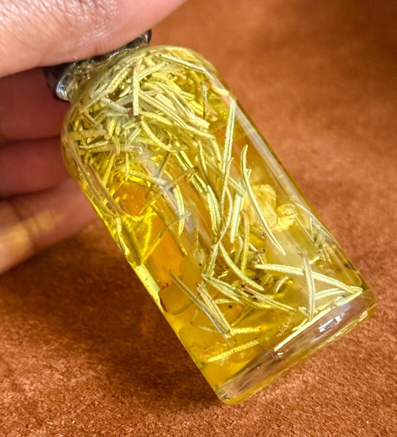 Puede incluir: Una peque&ntilde;a botella de vidrio llena de un l&iacute;quido amarillo y ramitas de romero.