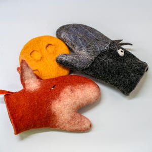 May include: Three felt oven mitts shaped like animals. A red fox, a gray wolf, and a yellow sun. The mitts are handmade and have a whimsical design.