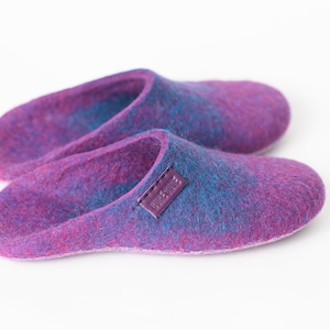 May include: A pair of purple and blue wool slippers with a leather label that says "BLUE MOON".