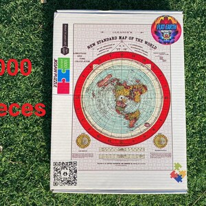 May include: A 1000 piece jigsaw puzzle featuring a flat earth map with a red border. The puzzle box has a QR code and the text "GLEASON'S NEW STANDARD MAP OF THE WORLD" and "FLAT EARTH PRODUCTS".