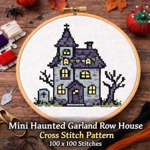 Könnte beinhalten: Ein Kreuzstichmuster eines Spukhauses in einem hölzernen Stickrahmen. Das Haus ist grau und lila mit gelben Fenstern, einem Kreuz oben und einem kleinen Friedhof. Der Text lautet "Mini Haunted Garland Row House Cross Stitch Pattern".