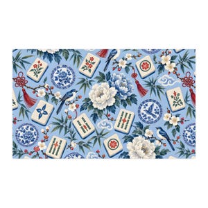 May include: A light blue fabric featuring a repeating pattern of mahjong tiles, blue and white floral plates, white and blue peonies, small birds, bamboo leaves, and red decorative tassels with knotted accents interspersed among white blossoms.