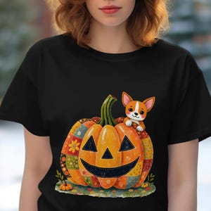 Puede incluir: Camiseta negra con un diseño de Halloween. Presenta una calabaza sonriente con un diseño de patchwork y un perro corgi. La calabaza es naranja con enredaderas verdes y detalles de tela coloridos.