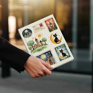 May include: A white journal with colorful illustrations of stamps featuring cityscapes, moons, and black cats. The journal is held by a person wearing a black blazer. The illustrations include the text "POST" and "JAYO".