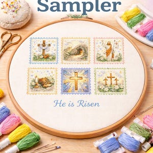May include: An Easter cross stitch sampler in a wooden embroidery hoop. The design shows six squares with religious images, the text "He is Risen", and the words "Easter Sampler" and "Cross Stitch Pattern". Colourful embroidery floss and scissors are also visible.
