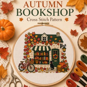 May include: A cross stitch pattern in a wooden hoop featuring an autumn bookshop with a red bicycle, a black cat, pumpkins, and colorful fall leaves. The text reads AUTUMN BOOKSHOP Cross Stitch Pattern, surrounded by scattered maple leaves.