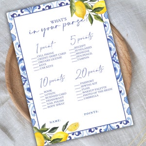 May include: A printable game card with a blue and white tiled pattern and lemons. The card has the title "What's in your purse?" and lists items with point values.  The items include: cell phone, credit/debit card, driver's license, keys, car keys, receipt, sunglasses, medicine, pen/pencil, tampon, book, lotion, business card, deodorant, nail polish, body spray, passport, sewing kit, floss, makeup palette, photo of the bride, and umbrella.