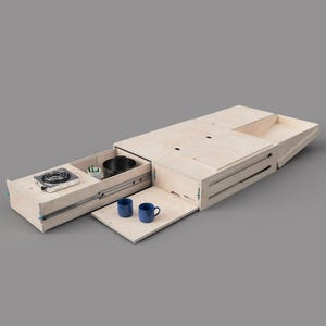 Puede incluir: Unidad de cocina de camping de madera clara con múltiples compartimentos y cajones. Incluye una pequeña estufa, una olla, dos tazas azules y otros elementos esenciales para acampar. Diseñada para cocinar y almacenar al aire libre.