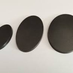 Könnte beinhalten: Drei schwarze, ovale Basen in verschiedenen Größen. Die Basen sind glatt und haben eine matte Oberfläche.