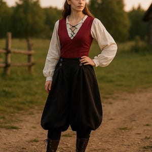 May include: A woman wearing a medieval-style outfit. The ensemble includes a burgundy vest with a laced neckline, a white blouse with puffy sleeves, and black, balloon-style pants. The outfit is completed with brown boots. The background features a wooden fence and a rustic building.