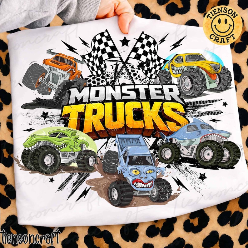 May include: White fabric with a vibrant graphic of monster trucks. The design showcases five cartoon monster trucks in different colours, the words "MONSTER TRUCKS" in yellow and black, and chequered flags.