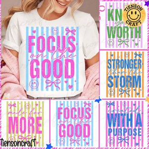 May include: White t-shirt with the text "FOCUS on the GOOD" in pink, set against a blue striped background. Additional designs include "KN yo WORTH", "STRONGER than the STORM", "made for MORE", and "created WITH A PURPOSE".