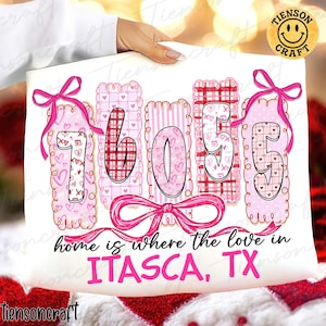 Puede incluir: Un cojín blanco con los números "76055" en rosa, decorado con corazones y lazos. El texto "home is where the love in ITASCA, TX" está escrito debajo. Un logotipo de "TIENSON CRAFT" está en la esquina superior derecha.