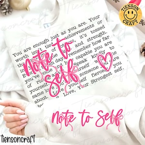 May include: A white sweatshirt with the words "Note to Self" in pink script, accented with pink bows and a heart. The sweatshirt also features a printed message in black text.