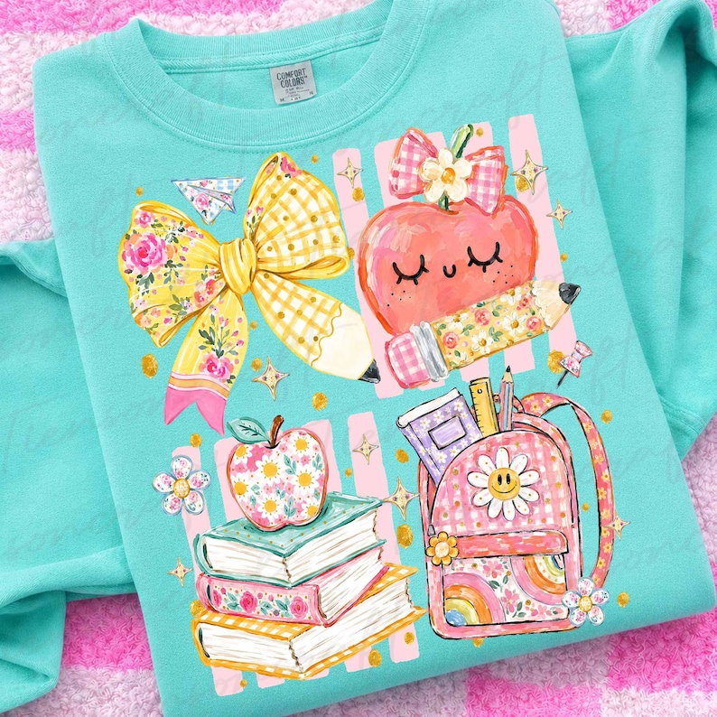 Pu&ograve; includere: Una felpa girocollo verde menta con una stampa grafica raffigurante un grande fiocco a quadretti gialli, una mela sorridente con un fiocco rosa, una pila di tre libri e uno zaino a quadretti rosa con una margherita e materiale scolastico.
