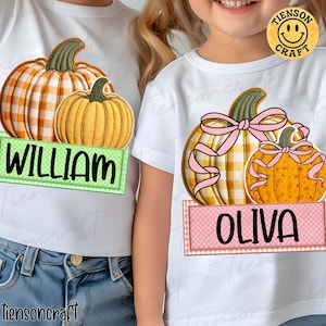 May include: White t-shirts with pumpkin graphics. One shirt features a large orange and yellow plaid pumpkin with the name "WILLIAM" on a green banner. The other shirt has two pumpkins with pink bows and the name "OLIVA" on a pink banner.