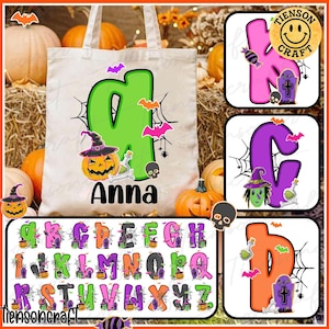 May include: A white tote bag with a green letter "A" featuring a jack-o'-lantern, bats, and spiderwebs. The name "Anna" is printed below. Additional alphabet letters with Halloween designs are displayed.