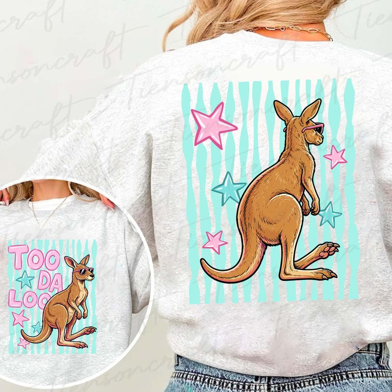 May include: A light grey sweatshirt with a kangaroo wearing sunglasses, set against a backdrop of blue stripes and pink and blue stars. The text "TOO DA LOO" is also displayed on the sweatshirt.