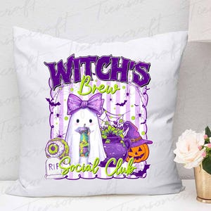 May include: White square pillow with a Halloween-themed design. The design features a ghost with a purple bow, a witch's cauldron, a jack-o'-lantern, and the text "Witch's Brew Social Club" in purple and green.