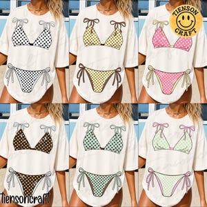 Peut inclure: T-shirts crème avec des motifs de bikinis à pois noirs, jaunes, roses, marron, turquoise et vert menthe. Chaque haut et bas de bikini est orné de nœuds. La marque "tiensoncraft" est visible.
