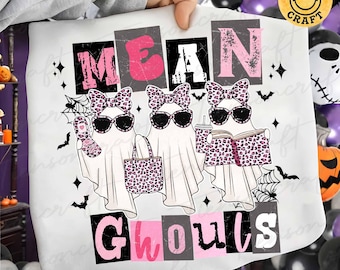 May include: A white t-shirt featuring a graphic of three ghosts wearing leopard print bows and sunglasses. The ghosts hold a flip phone, a tote bag, and a book. The text reads MEAN GHOULS in pink and black block letters with spiderwebs.
