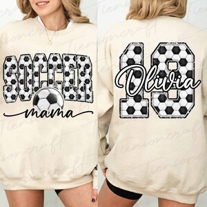 Pu&ograve; includere: Felpa beige con testo "SOCCER mama" e grafica di pallone da calcio sul davanti. Il retro presenta il numero 19 e il nome "Olivia" in un motivo a pallone da calcio. Un top comodo e casual per i tifosi di calcio.