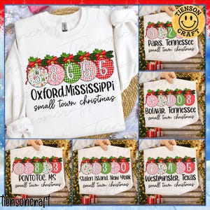 May include: White sweatshirt featuring a Christmas ornament design with the text "Oxford, Mississippi small town christmas" and the numbers "38655" inside the ornaments. Other images show tote bags with similar designs and different city names.