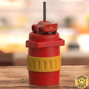 May include: A red cylindrical tumbler featuring a yellow textured band around the center and a red handle. A red toy race car with the number 95 on the back is attached to the lid, with a black straw extending vertically from the car's roof.